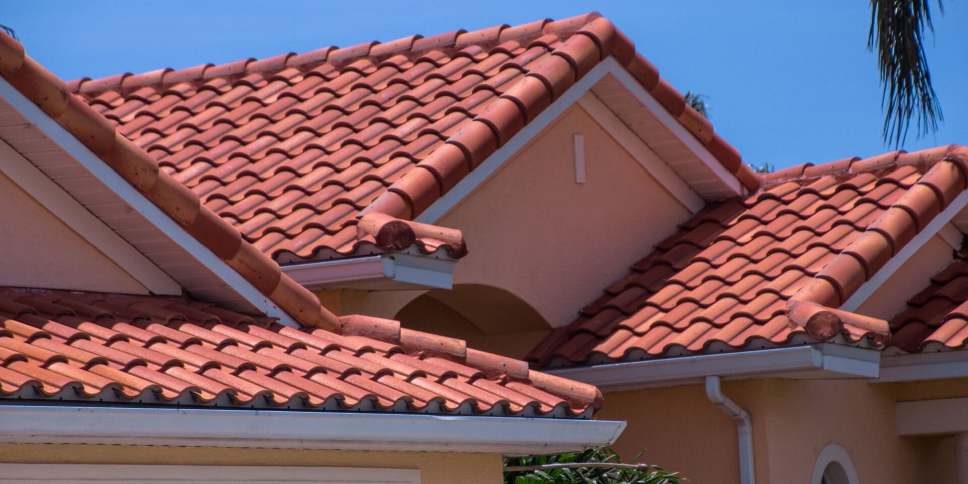 A closeup shot shows a beautiful home in Florida with a new red tile roof.