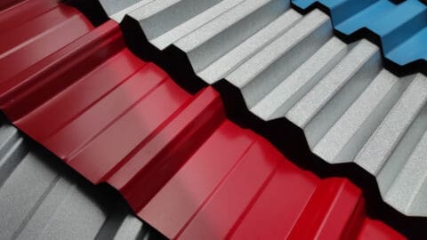 Different colors and types of metal roofing materials are stacked on top of each others.