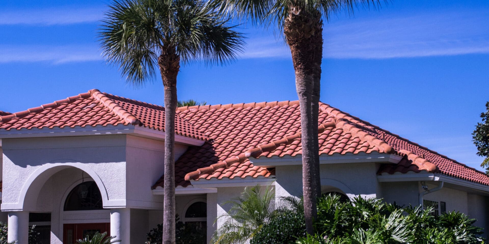 A beautiful Florida home stands in the sunshine with a new Spanish tile roof.