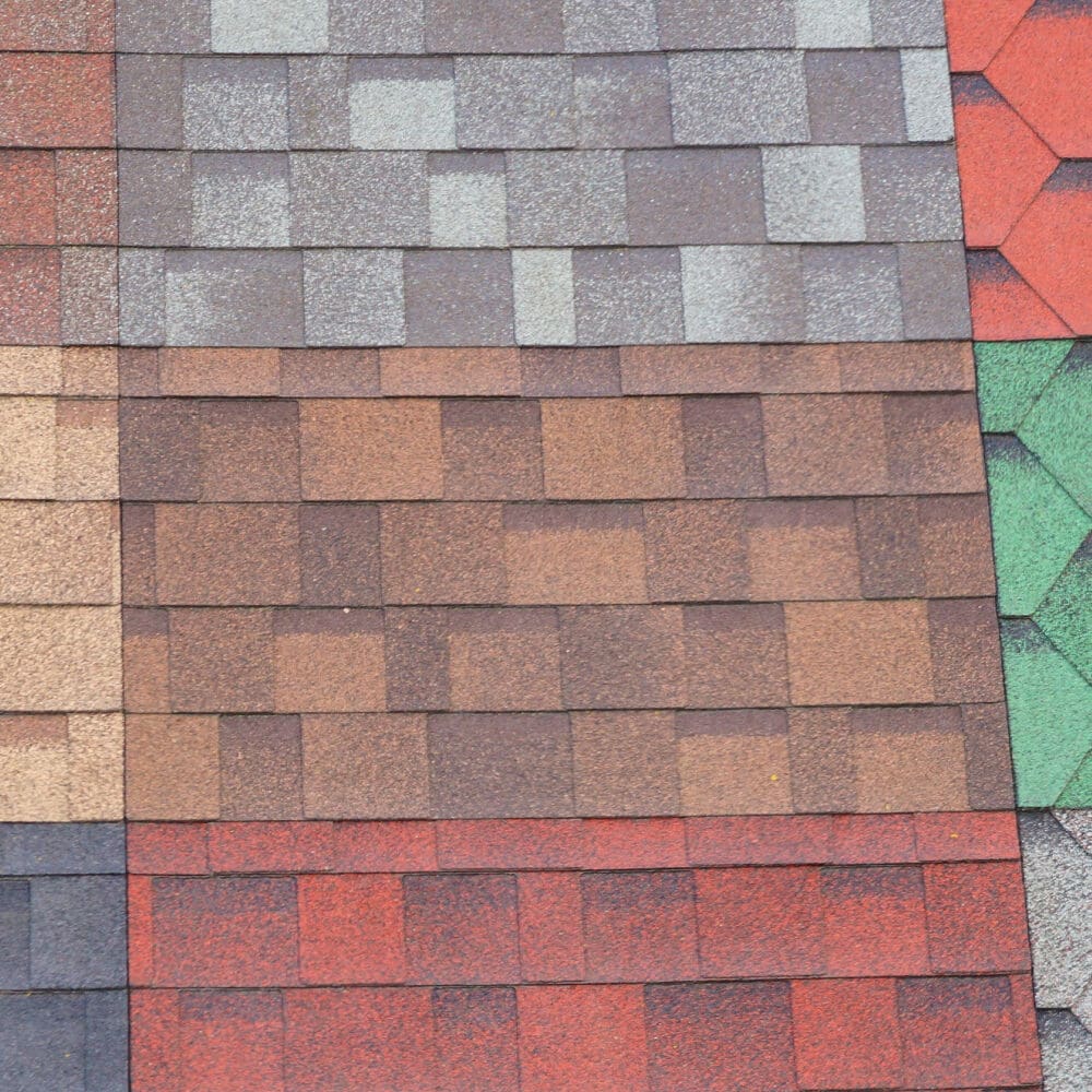 Different types and colors and textures of roofing shingles are shown next to each other.